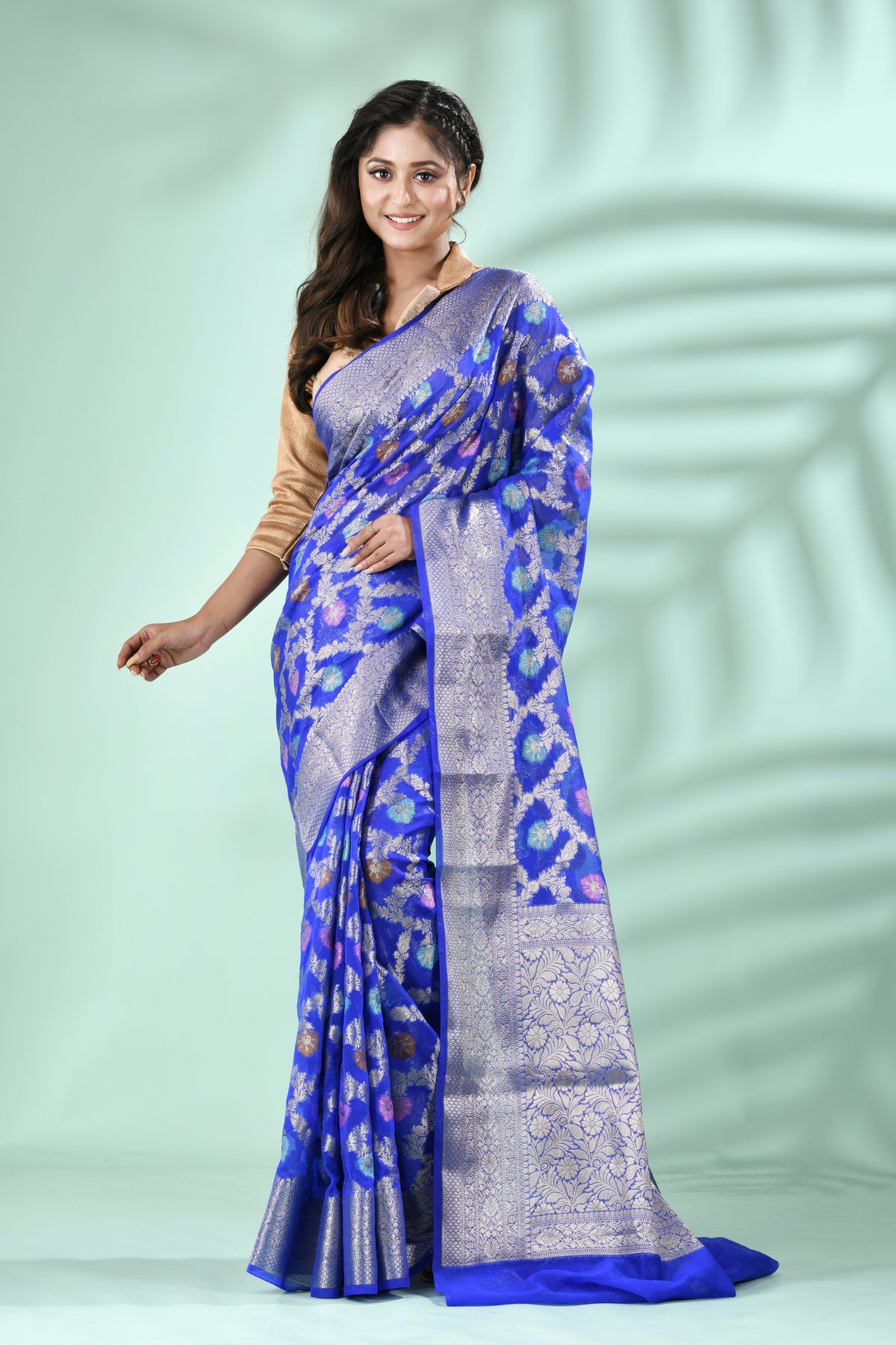 Royal Blue Banarasi Silk Saree with Antique Silver Zari Jal Weave, elegantly draped on a model against a soft green backgroun