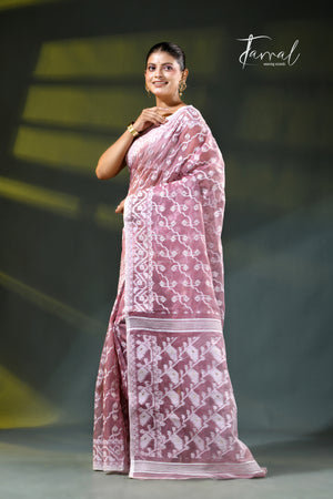 A woman modeling a onion pink and white patterned saree with a white blouse, accessorized with gold earrings, against a dark green gradient background. The brand name 'Farral' is visible in the top right corner.