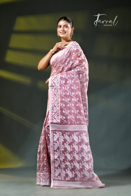 A woman modeling a onion pink and white patterned saree with a white blouse, accessorized with gold earrings, against a dark green gradient background. The brand name 'Farral' is visible in the top right corner.