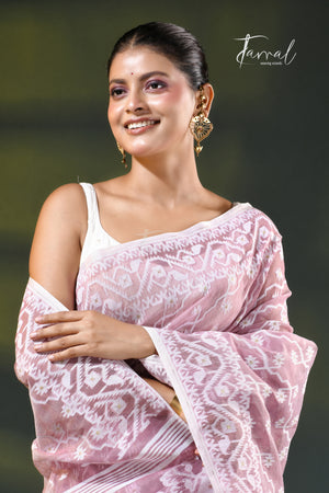 A woman modeling a onion pink and white patterned saree with a white blouse, accessorized with gold earrings, against a dark green gradient background. The brand name 'Farral' is visible in the top right corner.