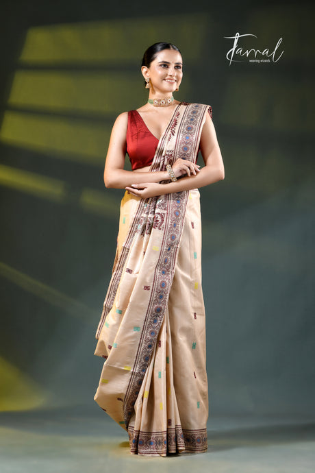 A woman modeling a beige saree with a red sleeveless blouse, standing against a dark stage-like background with yellow lighting. The saree has a patterned border in blue, brown, and gold, and the image features a 'Farral' brand watermark in the upper right.