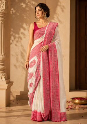 Woman wearing a white and pink saree in an indoor setting