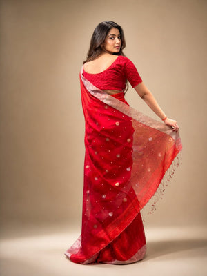 Woman wearing a red saree with a beige background