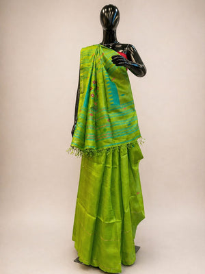 Green saree with a black blouse on a mannequin against a beige background
