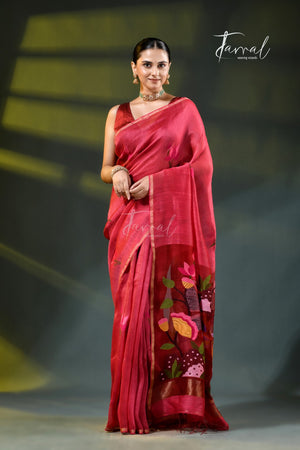 A woman modeling a vibrant red and pink saree with colorful floral embroidery on the border, standing against a dark studio background with yellow light beams. The brand name 'Farral' is visible as a watermark and logo.