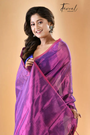Woman wearing a purple saree with a beige background